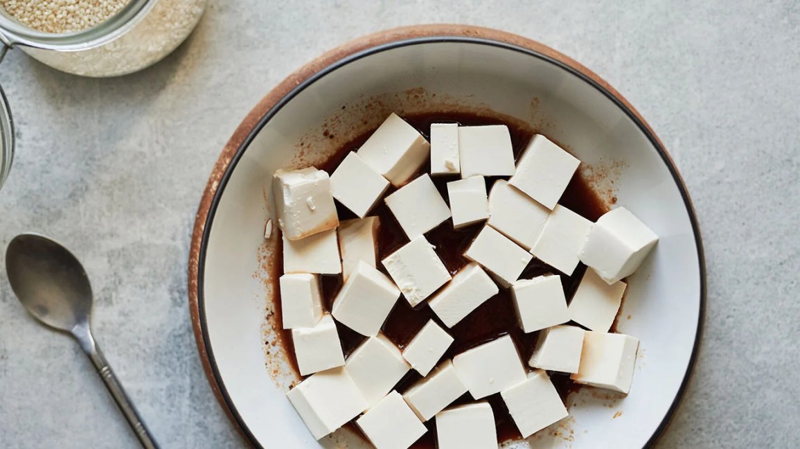 raw tofu in a bowl with soy sauce