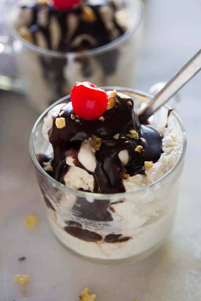 Hot Fudge Sauce 11 A cup full of vanilla ice cream with hot fudge, walnuts and a cherry on top.