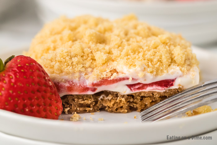 These strawberry crunch bars are easy to make and very delicious! This no bake strawberry crunch bars recipe with cookies is perfect for any occasion. These strawberry cookie bars are simple to make. You are going to love these strawberry crumb bars! #eatingonadime #easydesserts #strawberrydesserts 