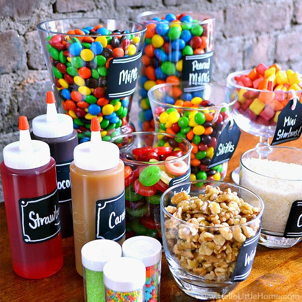 Syrups, candy, and toppings arranged together on a table.