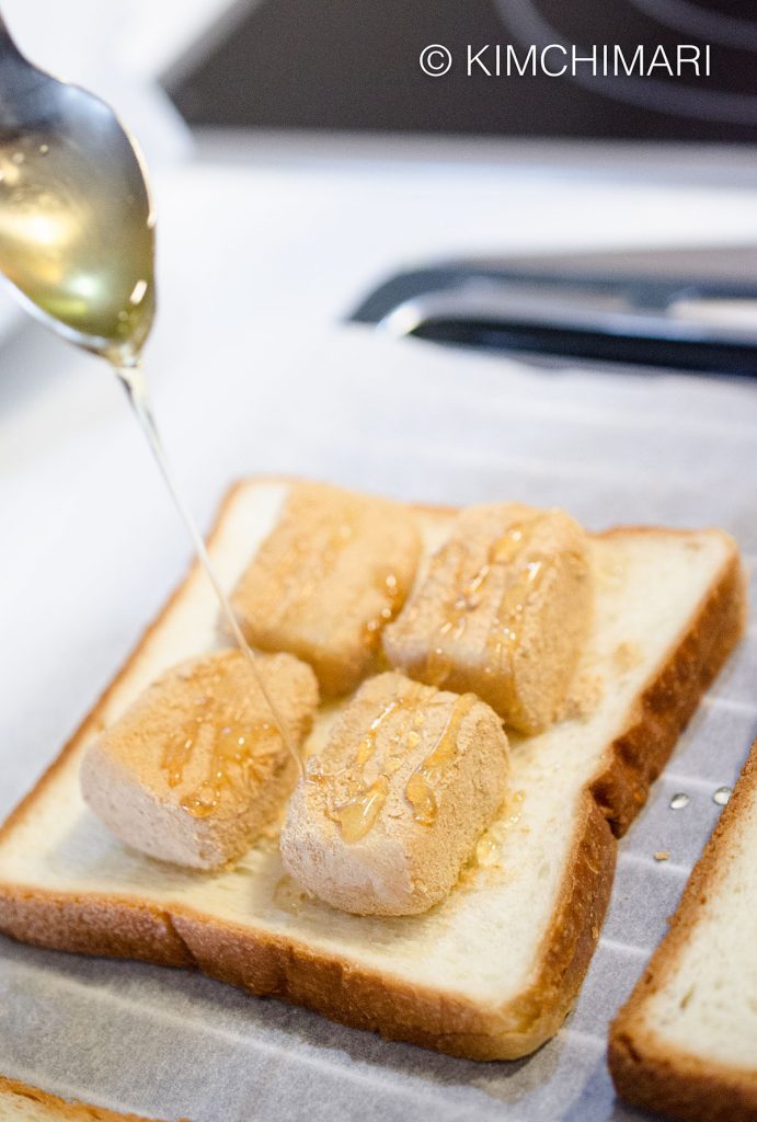 Drizzling honey on Injeolmi for Korean Rice Cake Sandwich