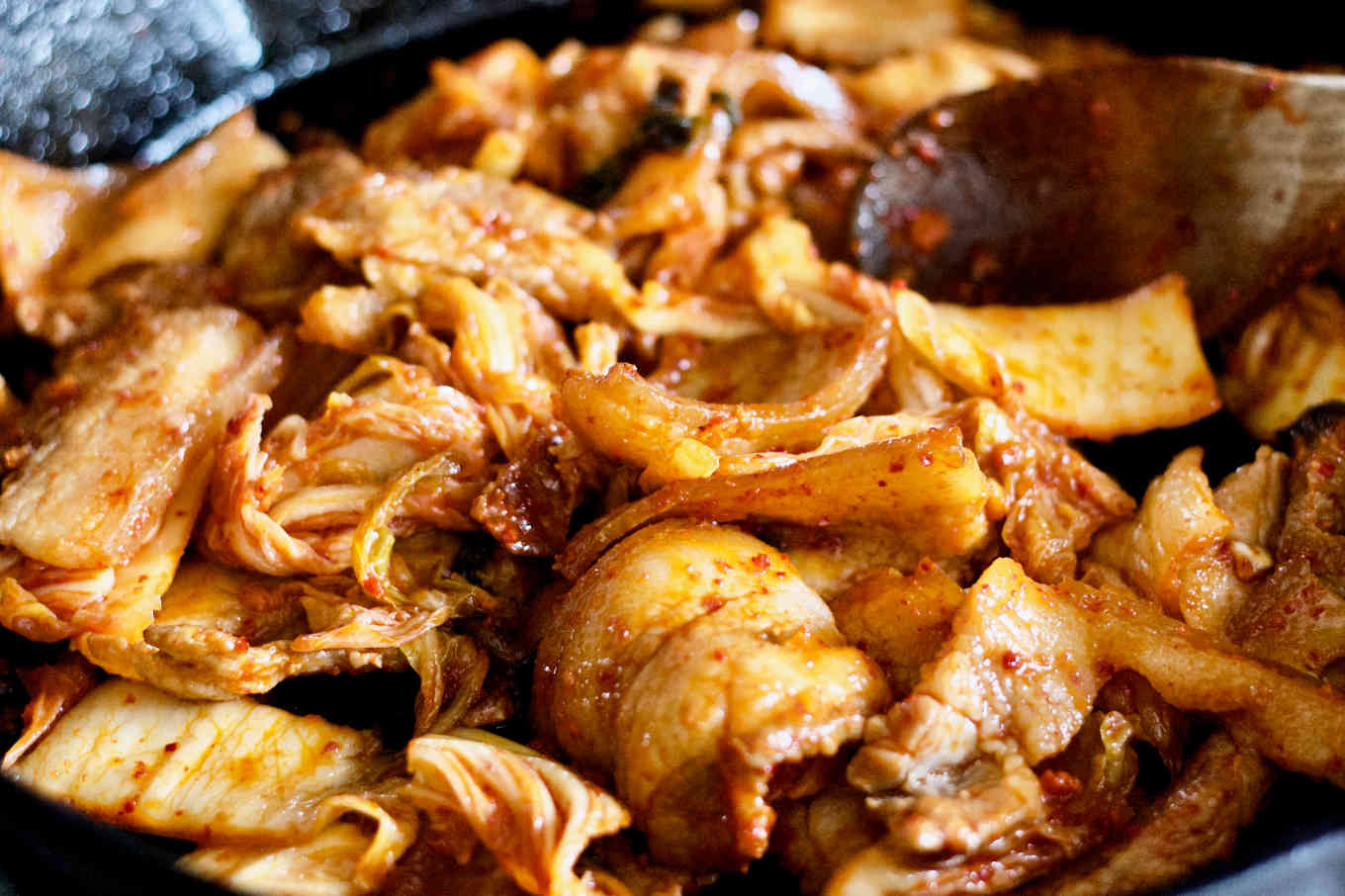 Easy Stir Fry Kimchi & Pork Belly 9 The dish is being cooked in a cast iron skillet. You can see the pork belly is browned and coated in kimchi juice.