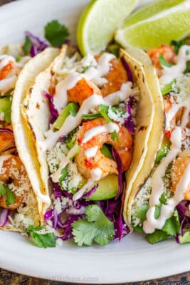 Shrimp taco up close on platter drizzled with sauce