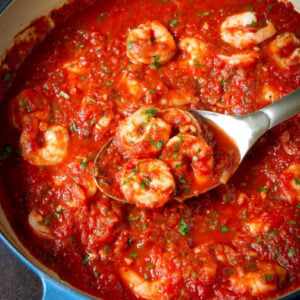 Shrimp in Red Sauce Recipe 23 Shrimp in red sauce with stainless steel spoon in skillet.