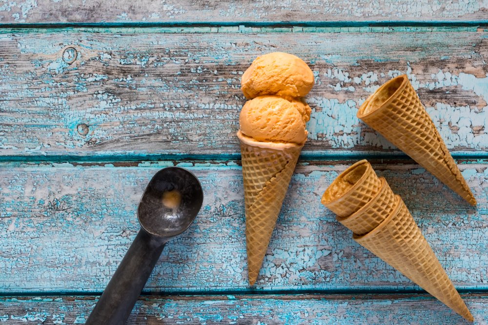 ice cream cone with empty sugar cones and an ice cream scooper