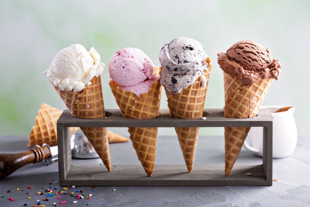Variety of ice cream scoops in waffle cones with chocolate, vanilla and strawberry